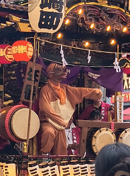 山車の上で、太鼓などを携えて踊る、たぬきの格好をした踊り手